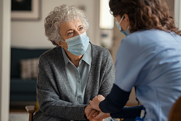 Doctor or nurse conversing with elderly patient
