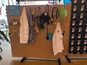 Doctor gear hanging up next to the all in for health desk